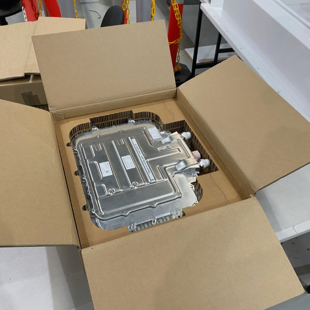 Custom cardboard insert securing an electronic component inside a Rebul shipping box for safe transi