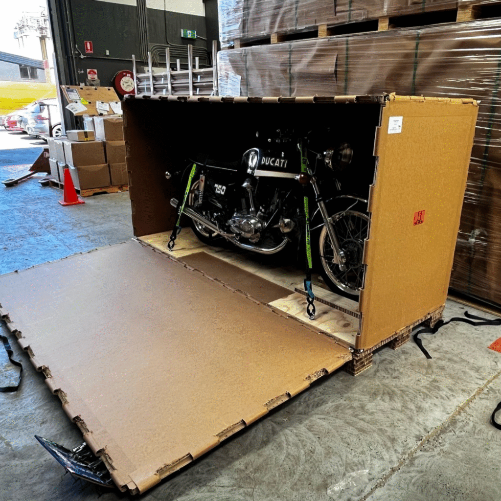 Vintage Ducati motorcycle secured inside a custom Rebul honeycomb board crate, showing durable and lightweight transport packaging.