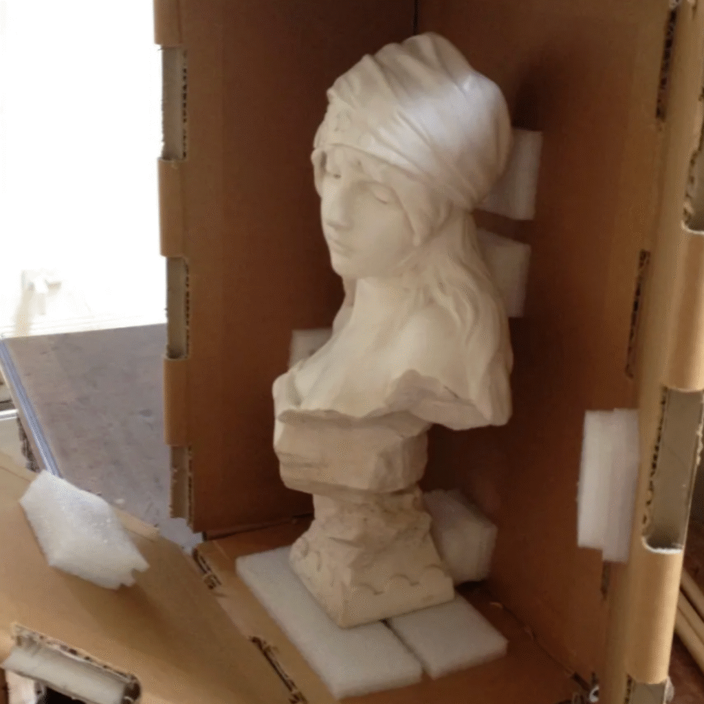 A white sculpture securely positioned inside a Rebul protective packing system with foam supports.